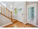 Bright entryway with hardwood floors, wooden stairs, a decorative glass door, and a sidelight, creating a welcoming ambiance at 2924 Fulton St, Denver, CO 80238