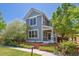 Inviting gray two-story home with manicured landscaping, white trim, a cozy covered porch, and a quaint picket fence at 2924 Fulton St, Denver, CO 80238