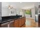 Open kitchen with granite countertop bar and stainless steel dishwasher with adjacent living area and hardwood flooring at 2924 Fulton St, Denver, CO 80238