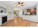 Bright open-concept living area with hardwood floors, a fireplace, and a view of the kitchen, perfect for entertaining at 2924 Fulton St, Denver, CO 80238