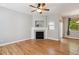 Open living room with hardwood floors, a ceiling fan, a fireplace, a patio door, and natural light, creating an inviting space at 2924 Fulton St, Denver, CO 80238