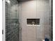 Sleek shower with gray tiled walls, niche, and glass enclosure at 2924 Fulton St, Denver, CO 80238