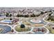 Bird's eye view of a suburban neighborhood featuring a community playground and roundabout surrounded by residential homes at 13144 E 109Th Pl, Commerce City, CO 80022