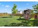 Spacious backyard with green lawn, wooden fence and a playset at 13144 E 109Th Pl, Commerce City, CO 80022