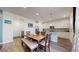 Spacious dining area adjacent to the kitchen, featuring a wooden table and a breakfast bar at 13144 E 109Th Pl, Commerce City, CO 80022