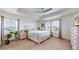 Bright main bedroom with large windows, tray ceiling, and a comfortable king-size bed at 13144 E 109Th Pl, Commerce City, CO 80022