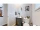 Stylish powder room featuring a modern vanity with sleek fixtures and an oval mirror at 13144 E 109Th Pl, Commerce City, CO 80022