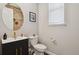 Chic powder room with wood accent wall, black vanity, and modern fixtures at 13144 E 109Th Pl, Commerce City, CO 80022