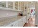 Modern kitchen with granite countertops, white cabinets, stainless steel appliances, and hardwood floors at 21606 E Idyllwilde Dr, Parker, CO 80138