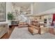 An expansive living room with a cozy leather sofa adjacent to the staircase and kitchen at 21606 E Idyllwilde Dr, Parker, CO 80138