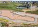Aerial view of the community's horse arena with surrounding fences and community homes at 1425 Hart Ln, Elizabeth, CO 80107
