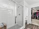Bathroom features a walk-in shower with a glass door, white tile, and a view of the toilet and walk-in closet at 1425 Hart Ln, Elizabeth, CO 80107