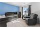 Bedroom with gray crib, changing table, dresser, and comfortable chair at 1425 Hart Ln, Elizabeth, CO 80107