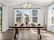 Bright dining area with large windows, a chandelier, and a stylish wooden table with seating for six at 1425 Hart Ln, Elizabeth, CO 80107