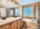 Bright bathroom featuring a double vanity, soaking tub, and walk-in shower at 9865 Centre Cir, Parker, CO 80134