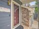 Welcoming front door with sidelight, stone accents, and blue siding at 9865 Centre Cir, Parker, CO 80134