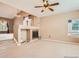 Cozy living room featuring a fireplace, ceiling fan, and bright windows at 9865 Centre Cir, Parker, CO 80134