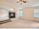 Open-concept living room with fireplace, carpet, and lots of natural light from the windows at 9865 Centre Cir, Parker, CO 80134