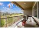 Relax on the covered balcony with a cozy seating area and views at 16902 W 94Th Pl, Arvada, CO 80007