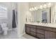 Bathroom boasts double vanity, tile floors, and shower over tub combination at 16902 W 94Th Pl, Arvada, CO 80007