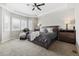 Bedroom features tray ceiling, carpet flooring, and a relaxing sitting area by the windows at 16902 W 94Th Pl, Arvada, CO 80007