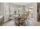 Dining area with views to the balcony featuring wood floors, modern lighting, and plantation shutters at 16902 W 94Th Pl, Arvada, CO 80007