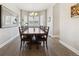 Dining room featuring a chandelier, large mirror, and a bay window with shutter-style window coverings at 16902 W 94Th Pl, Arvada, CO 80007