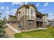 Charming home showcasing a stone and siding exterior, a well-maintained lawn, and a cozy patio at 16902 W 94Th Pl, Arvada, CO 80007