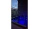 Hot tub with blue underwater lighting, surrounded by a stone wall and view of neighborhood at 16902 W 94Th Pl, Arvada, CO 80007