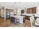 Open kitchen features a large island, stainless appliances, dark wood cabinetry, and wood floors at 16902 W 94Th Pl, Arvada, CO 80007