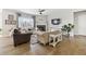 Bright living room with hardwood floors, a fireplace, and large windows for natural light at 16902 W 94Th Pl, Arvada, CO 80007