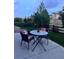 Outdoor patio with a glass table and seating, surrounded by a well-maintained lawn and garden at 16902 W 94Th Pl, Arvada, CO 80007