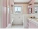 Charming bathroom with pink accents, floral wallpaper, and a vintage-style bathtub at 2225 Linda Vista Dr, Lakewood, CO 80215