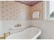 Traditional bathroom boasting floral wallpaper, wainscoting and a classic clawfoot tub with gold-tone fixtures at 2225 Linda Vista Dr, Lakewood, CO 80215