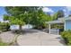 View of a long concrete driveway leading to the house and detached garage amidst lush trees at 2225 Linda Vista Dr, Lakewood, CO 80215