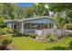 Charming blue home with a white trim, a spacious porch and mature landscaping at 2225 Linda Vista Dr, Lakewood, CO 80215