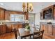 Warm kitchen featuring custom wood cabinets, granite counters, and adjacent dining area at 2225 Linda Vista Dr, Lakewood, CO 80215