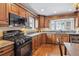 Bright kitchen with wooden cabinetry, granite counters, and stainless steel stove at 2225 Linda Vista Dr, Lakewood, CO 80215