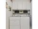 Bright laundry room features a white washer and dryer with white cabinets and decor at 2225 Linda Vista Dr, Lakewood, CO 80215