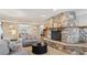Beautiful living room with a stone fireplace, inviting seating, and views into the dining room at 2225 Linda Vista Dr, Lakewood, CO 80215