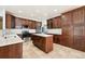 Kitchen with an island, stainless steel appliances, and wood cabinets at 16586 E 99Th Pl, Commerce City, CO 80022