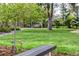 Serene backyard setting with a wooden swing, garden bench, and vibrant green lawn at 6975 S Chase Ct, Littleton, CO 80128