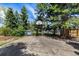 Outdoor basketball court surrounded by mature trees and a shed, offering recreational opportunities and outdoor activities at 6975 S Chase Ct, Littleton, CO 80128