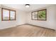 Bedroom featuring wood floors and two windows with wood trim, providing ample light at 6975 S Chase Ct, Littleton, CO 80128