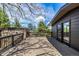 Spacious wooden deck with black railings, offering outdoor relaxation and scenic views, with sliding glass door access at 6975 S Chase Ct, Littleton, CO 80128