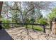 A spacious wooden deck with black railings overlooks a well-maintained backyard with lush greenery and mature trees at 6975 S Chase Ct, Littleton, CO 80128