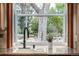 Kitchen sink with black faucet and marble countertops overlooks large backyard tree and lush landscaping at 6975 S Chase Ct, Littleton, CO 80128