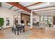 Open-concept living and dining room with exposed beams and a brick fireplace at 6975 S Chase Ct, Littleton, CO 80128