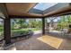 Covered outdoor patio area with skylight, featuring a brick surface, landscaping, and plenty of space for entertaining at 6975 S Chase Ct, Littleton, CO 80128