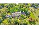Stunning aerial view of estate home surrounded by lush trees and landscaped grounds at 1700 E Tufts Ave, Cherry Hills Village, CO 80113